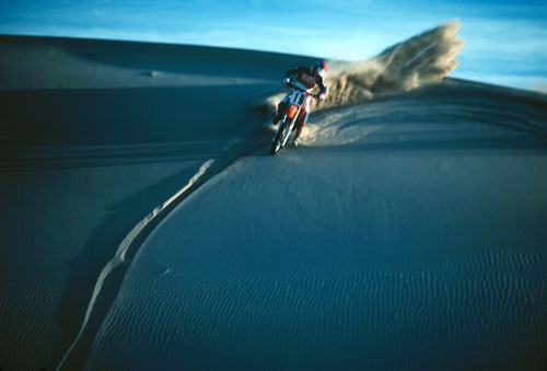 Photo of motorcycle racing on sand dune