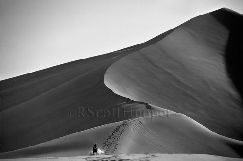 Photo of sand dunes with horse and rider in distance