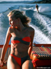 Photo of woman in bikini on boat with water skier